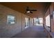 Covered porch with brick and wood, featuring a ceiling fan and double doors leading indoors at 7790 Stratford Ln, Atlanta, GA 30350