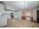 Open concept kitchen with white cabinets, stainless steel appliances, and chandelier lighting at 40 Heather Woods Ct, Covington, GA 30016
