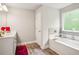 Bright bathroom featuring a soaking tub, modern fixtures and a large window with natural light at 5662 Valley Loop, Fairburn, GA 30213