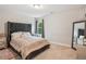 Cozy bedroom featuring a stylish bed, a window and a full-length mirror, offering a comfortable space at 5662 Valley Loop, Fairburn, GA 30213