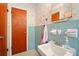 Functional bathroom with blue tiling, a vanity, and wallpaper accents, providing a vintage-style space for personal care at 6126 Knights Ln, Douglasville, GA 30135