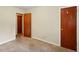 Simple bedroom showing two interior doors, neutral walls, carpet, and functional space, ideal for customization at 6126 Knights Ln, Douglasville, GA 30135