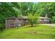 Traditional brick home with a sloped lawn and mature trees, perfect for enjoying outdoor living and relaxation at 6126 Knights Ln, Douglasville, GA 30135