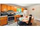 Eat-in kitchen featuring stainless steel appliances, wood cabinets, and a dining area, providing a functional space at 6126 Knights Ln, Douglasville, GA 30135