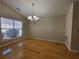 Well lit dining room with hardwood floors, a modern chandelier, and a large window at 983 Noble Oak Ct, Lawrenceville, GA 30046