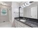 Bright bathroom featuring a granite vanity top, updated lighting, and tiled shower at 1904 Britt Dr, Snellville, GA 30078