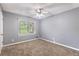 Cozy bedroom with neutral carpet, a ceiling fan, and a large window for natural light at 1904 Britt Dr, Snellville, GA 30078