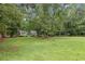 Single-story home in a neighborhood featuring a green lawn and mature trees at 1904 Britt Dr, Snellville, GA 30078