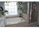 Bathroom featuring a soaking tub and glass-enclosed shower, filled with natural light at 1951 Barrett Knoll Nw Cir, Kennesaw, GA 30152