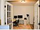 Home office framed by french doors includes two large monitors, modern desk, and track lighting at 1951 Barrett Knoll Nw Cir, Kennesaw, GA 30152