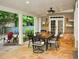 Covered patio with stone flooring features a dining table set, grill area, and backyard views at 1951 Barrett Knoll Nw Cir, Kennesaw, GA 30152