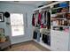 View of custom organized walk-in closet with shelving, a window, and a chair at 1951 Barrett Knoll Nw Cir, Kennesaw, GA 30152