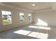 A bright and airy bedroom features tray ceilings and three windows overlooking a yard at 324 Bloomfield Cir, Canton, GA 30114