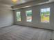 A bright bedroom features three windows overlooking a treed yard and neutral carpet at 324 Bloomfield Cir, Canton, GA 30114