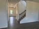 An entryway leads into a home with wood-grain vinyl flooring and a carpeted staircase with dark wood railings at 324 Bloomfield Cir, Canton, GA 30114