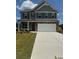 Two-story home boasts stone accents, a neutral color palette, an attached two car garage, and well manicured front lawn at 324 Bloomfield Cir, Canton, GA 30114