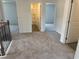 Upstairs hallway featuring carpeted flooring and doors leading to a bathroom and other rooms at 324 Bloomfield Cir, Canton, GA 30114