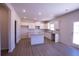 Bright kitchen featuring white cabinets, granite countertops, and an island with wood grain vinyl flooring at 324 Bloomfield Cir, Canton, GA 30114