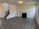 An open-concept living room features a fireplace, wood-grain vinyl floors, and a carpeted staircase at 324 Bloomfield Cir, Canton, GA 30114