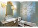 Charming powder room with designer wallpaper and beautiful vanity with an ornate mirror at 6440 Westchester Pl, Cumming, GA 30040