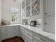 Elegant butler's pantry with custom gray cabinetry, marble countertops, and a window providing natural light at 6440 Westchester Pl, Cumming, GA 30040