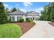Two-story home with manicured landscaping, a dark roof, blue shutters and a circular driveway at 6440 Westchester Pl, Cumming, GA 30040