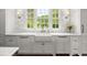 Close-up view of a stylish farmhouse sink with marble countertops and modern hardware at 6440 Westchester Pl, Cumming, GA 30040