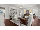 Bright living room with hardwood floors, a decorative fireplace, a cozy couch, and built-in bookshelves at 6440 Westchester Pl, Cumming, GA 30040