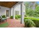 Covered brick patio features classic columns, outdoor seating, and a view of the lush, landscaped backyard at 6440 Westchester Pl, Cumming, GA 30040