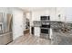 Well-lit kitchen with stainless steel appliances, granite countertops and tile backsplash at 8605 Stone Creek Ct, Douglasville, GA 30135