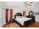 Main bedroom featuring hardwood floors, ceiling fan, large window and decorative bedside lamps at 8605 Stone Creek Ct, Douglasville, GA 30135
