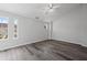 Large bedroom with gray wood flooring, multiple windows, and a ceiling fan at 1510 Paramount Ln, Sugar Hill, GA 30518