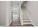 Bright entryway with hardwood floors, stairs with white railing, and an open view into the living area at 1510 Paramount Ln, Sugar Hill, GA 30518