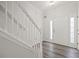 Inviting entryway with hardwood floors, stairs with white railing, and a bright white front door at 1510 Paramount Ln, Sugar Hill, GA 30518