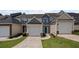 Charming townhome featuring an attached garage, a blue front door, and manicured landscaping at 1510 Paramount Ln, Sugar Hill, GA 30518