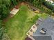 Aerial view shows a large backyard with a basketball court, fire pit, and patio at 412 Mill Stream Way, Woodstock, GA 30188