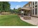 A well-maintained backyard features a stone fire pit and covered patio area at 412 Mill Stream Way, Woodstock, GA 30188