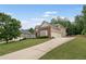 View of the home's exterior and driveway with mature trees and landscaping at 412 Mill Stream Way, Woodstock, GA 30188