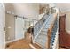 Inviting foyer featuring hardwood floors, staircase, and a sliding barn door to an office at 412 Mill Stream Way, Woodstock, GA 30188