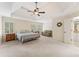 Spacious main bedroom with natural light, a ceiling fan, and a cozy seating area at 412 Mill Stream Way, Woodstock, GA 30188