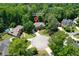 An aerial view reveals a stunning home on a lush, wooded lot, complete with a circular driveway and manicured landscaping at 5602 Asheforde Ln, Marietta, GA 30068