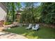 This meticulously designed backyard boasts plush turf, stone details, and comfortable lounge seating for relaxation at 5602 Asheforde Ln, Marietta, GA 30068
