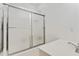Bright bathroom featuring a shower with frosted glass doors, white walls, and a modern sink at 5602 Asheforde Ln, Marietta, GA 30068