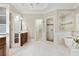 Bright bathroom featuring a tub, walk-in shower, and dual access to the walk-in closet at 5602 Asheforde Ln, Marietta, GA 30068