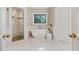 Elegant bathroom with freestanding tub, glass shower, and decorative window at 5602 Asheforde Ln, Marietta, GA 30068