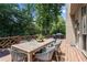 Exterior deck with dining table, seating, and view of mature trees at 5602 Asheforde Ln, Marietta, GA 30068