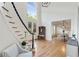 Bright foyer boasts hardwood floors, staircase, coat rack with bench, and open access to dining area at 5602 Asheforde Ln, Marietta, GA 30068