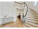 Bright foyer featuring wood floors, curved staircase with black trim, and light walls at 5602 Asheforde Ln, Marietta, GA 30068