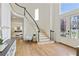 Bright foyer with wood floors, black-trimmed staircase, stained glass front doors and light walls at 5602 Asheforde Ln, Marietta, GA 30068