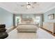 Comfortable primary bedroom with a tray ceiling, ceiling fan, and bench at the end of the bed at 5602 Asheforde Ln, Marietta, GA 30068